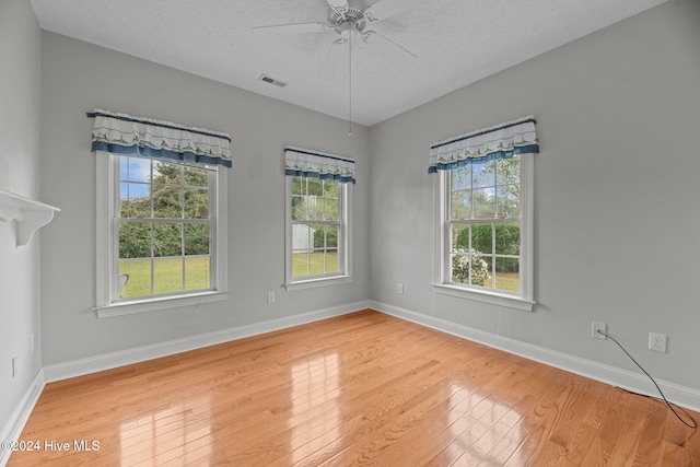 unfurnished room with ceiling fan, hardwood / wood-style floors, and a healthy amount of sunlight