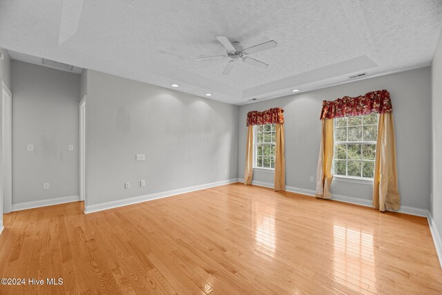 unfurnished room featuring ceiling fan, light hardwood / wood-style flooring, and a textured ceiling