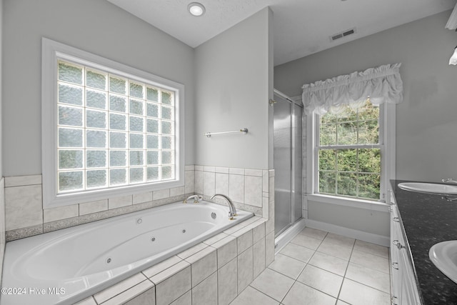 bathroom with tile patterned flooring, vanity, and a healthy amount of sunlight