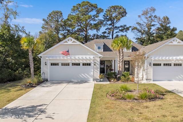 1296 Marsilio Ln SW Unit A, Ocean Isle Beach, NC 28469 - view of front of house featuring a garage, driveway, a front yard, and a shingled roof