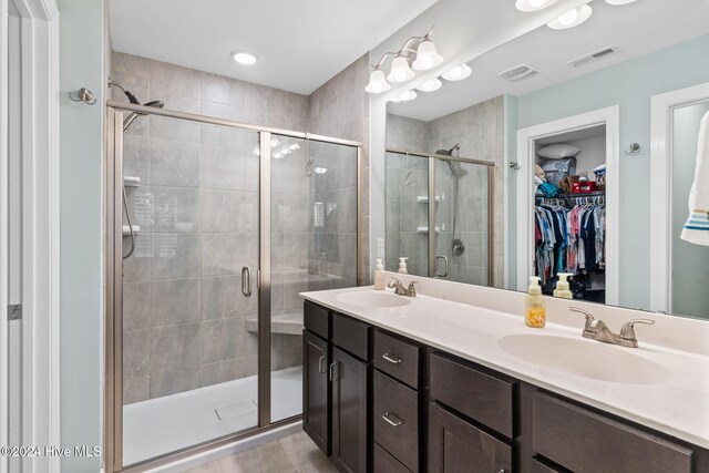 1296 Marsilio Ln SW Unit A, Ocean Isle Beach, NC 28469 - bathroom with a shower stall, double vanity, a walk in closet, and tile patterned floors