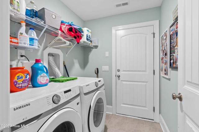 laundry area with light tile patterned floors and washing machine and clothes dryer