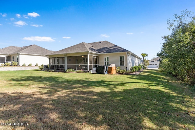 back of property with a sunroom, a lawn, and a garage