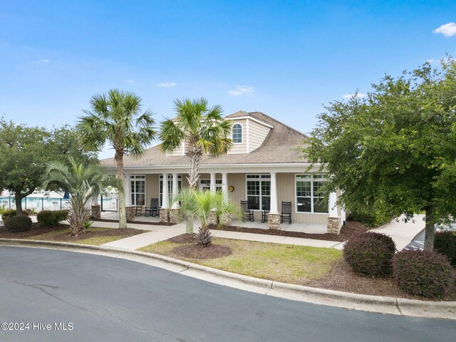 1296 Marsilio Ln SW Unit A, Ocean Isle Beach, NC 28469 - view of front of property with stone siding, covered porch, and a shingled roof