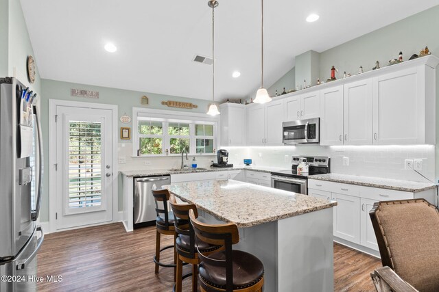 1296 Marsilio Ln SW Unit A, Ocean Isle Beach, NC 28469 - kitchen featuring appliances with stainless steel finishes, a sink, lofted ceiling, white cabinetry, and tasteful backsplash