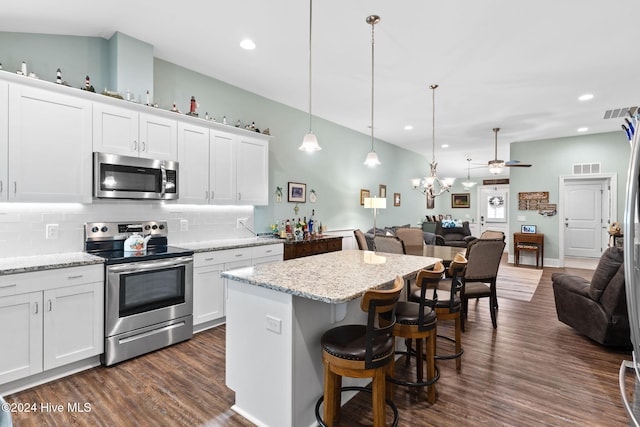 1296 Marsilio Ln SW Unit A, Ocean Isle Beach, NC 28469 - kitchen featuring appliances with stainless steel finishes, open floor plan, backsplash, dark wood-style flooring, and white cabinets