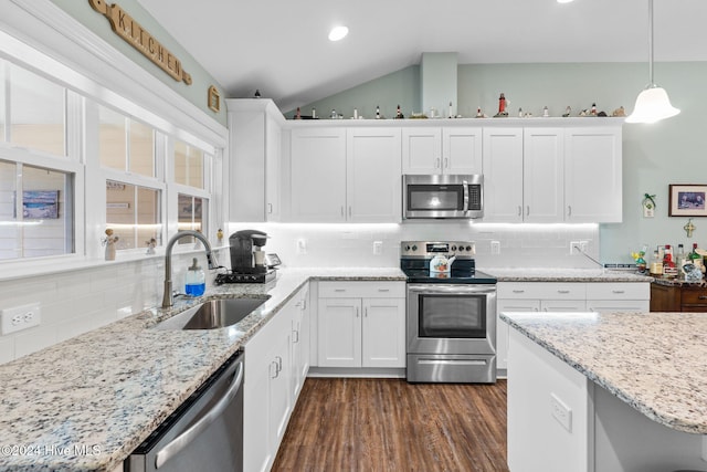 kitchen featuring appliances with stainless steel finishes, pendant lighting, sink, white cabinets, and dark wood-type flooring