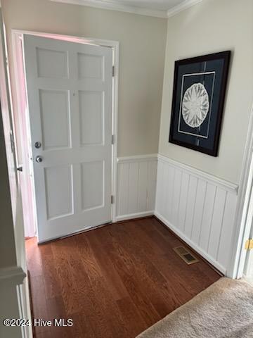 foyer featuring dark wood-type flooring and ornamental molding