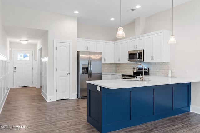 kitchen with pendant lighting, stainless steel appliances, white cabinetry, and dark hardwood / wood-style floors