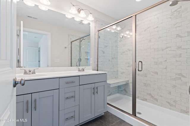 bathroom featuring a shower with door, vanity, and tile patterned floors