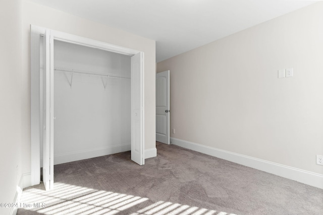 unfurnished bedroom with a closet and light carpet