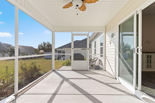 unfurnished sunroom with ceiling fan