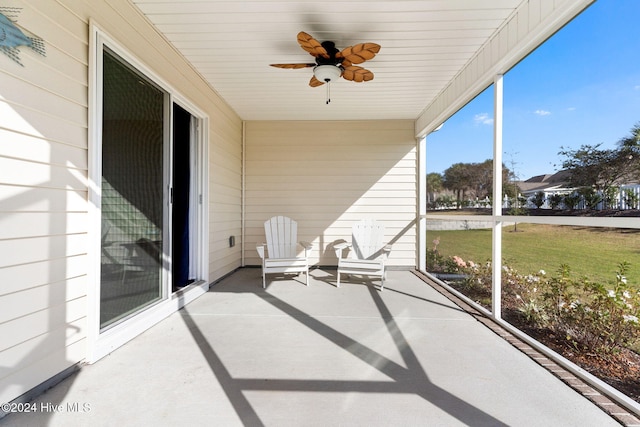 unfurnished sunroom with ceiling fan