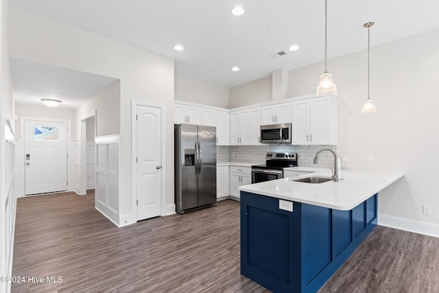 kitchen with white cabinetry, appliances with stainless steel finishes, pendant lighting, sink, and dark wood-type flooring