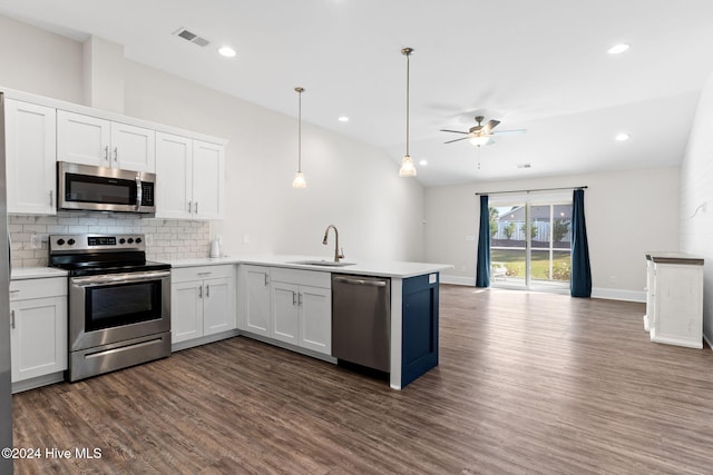 kitchen with sink, appliances with stainless steel finishes, dark hardwood / wood-style floors, white cabinets, and pendant lighting