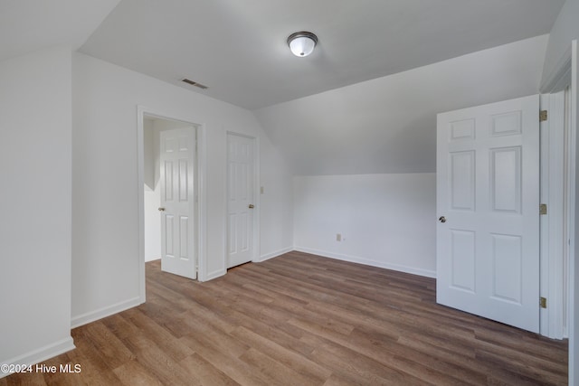 additional living space featuring lofted ceiling and hardwood / wood-style floors