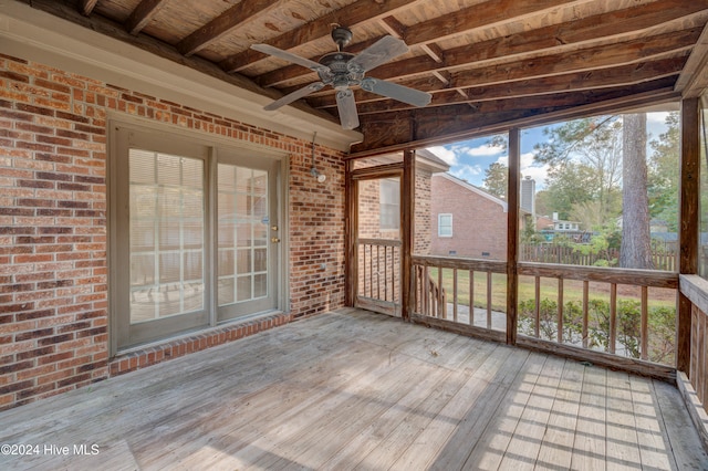 unfurnished sunroom with lofted ceiling with beams, ceiling fan, and wood ceiling