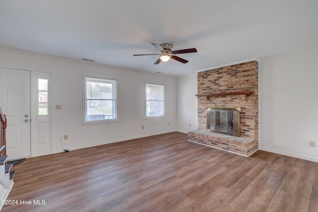 unfurnished living room with crown molding, wood-type flooring, ceiling fan, and a fireplace