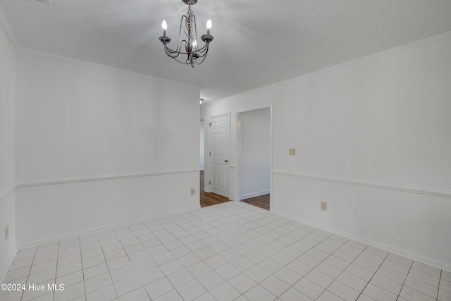 spare room featuring ornamental molding, a chandelier, and light tile patterned floors