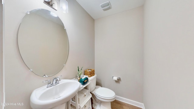 bathroom with hardwood / wood-style floors, toilet, and sink