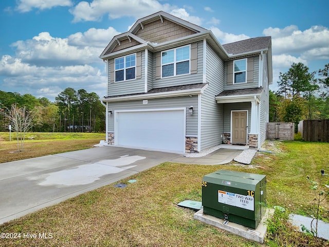 craftsman inspired home with a garage and a front lawn