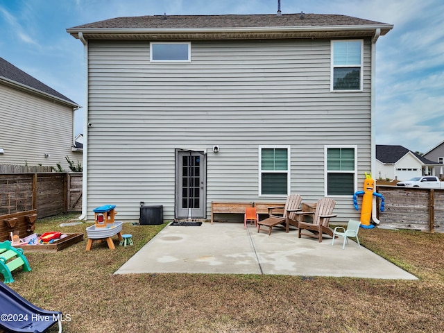 back of property with a patio area and a lawn