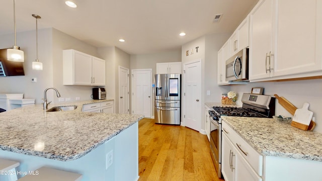 kitchen with white cabinets, pendant lighting, stainless steel appliances, and sink