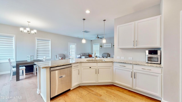 kitchen featuring white cabinetry, dishwasher, hanging light fixtures, light hardwood / wood-style flooring, and ceiling fan with notable chandelier