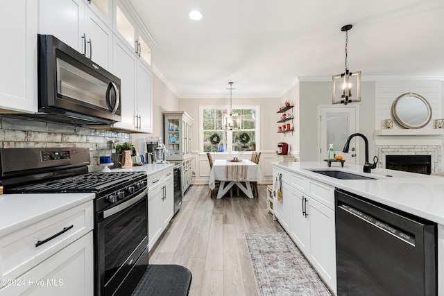 kitchen with hanging light fixtures, sink, dishwasher, stainless steel gas stove, and a chandelier