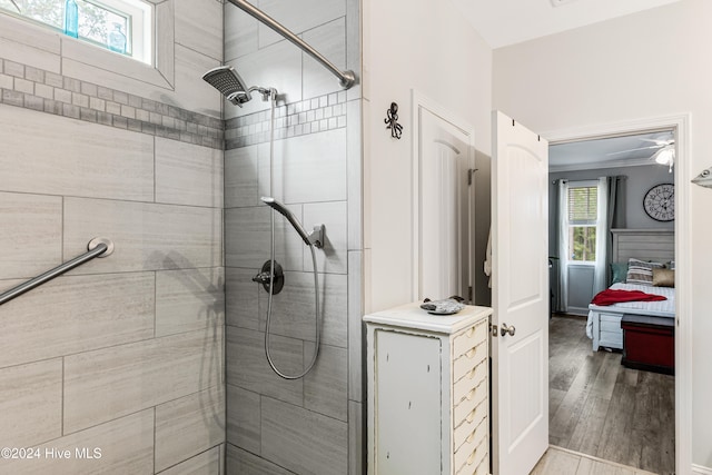 bathroom with wood-type flooring and a tile shower