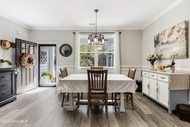 dining area with crown molding, a notable chandelier, and wood-type flooring