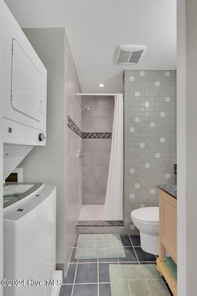 bathroom with a shower with curtain, vanity, stacked washing maching and dryer, and tile patterned floors