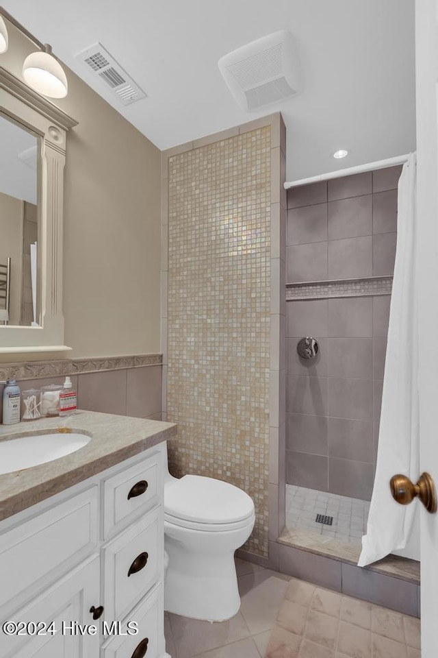 bathroom featuring tile patterned floors, toilet, vanity, tile walls, and a shower with shower curtain