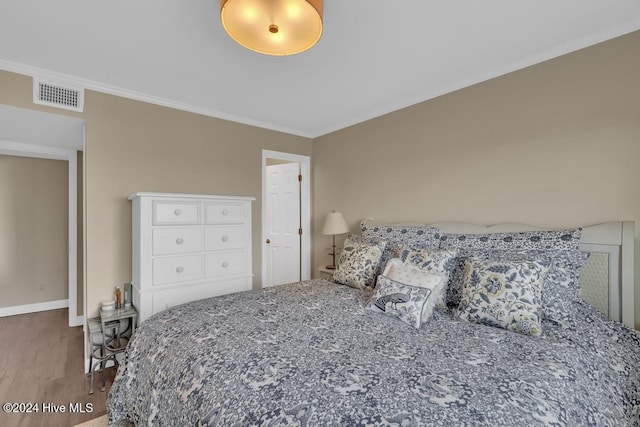 bedroom with hardwood / wood-style flooring and crown molding