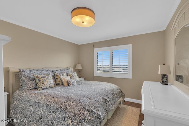 bedroom with hardwood / wood-style flooring and ornamental molding