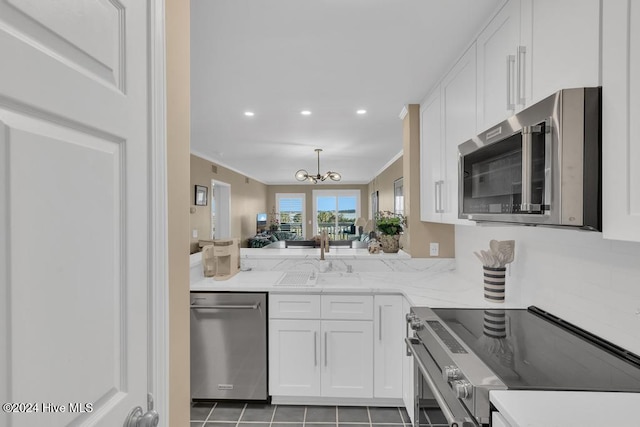 kitchen featuring white cabinetry, sink, stainless steel appliances, a notable chandelier, and tile patterned floors