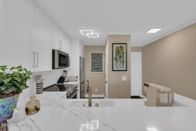 kitchen featuring white cabinets, stainless steel appliances, light stone counters, and sink