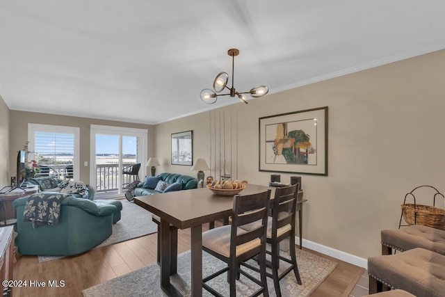 dining area featuring hardwood / wood-style floors, ornamental molding, and a notable chandelier