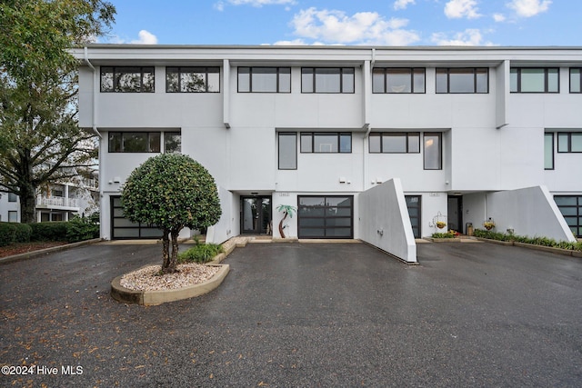 view of building exterior with aphalt driveway and an attached garage