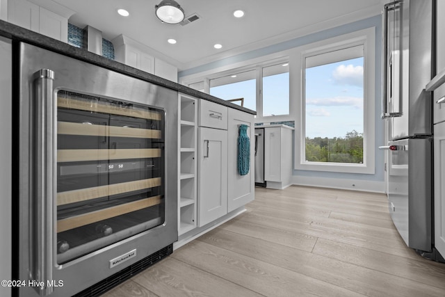 kitchen featuring white cabinetry, high quality fridge, beverage cooler, and light hardwood / wood-style flooring