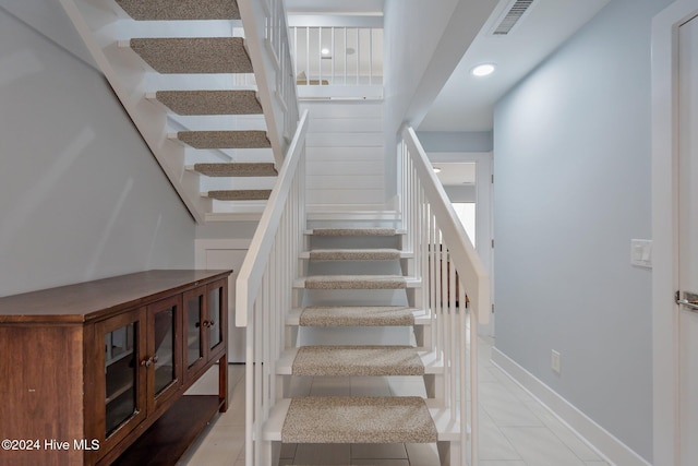 stairway with tile patterned floors