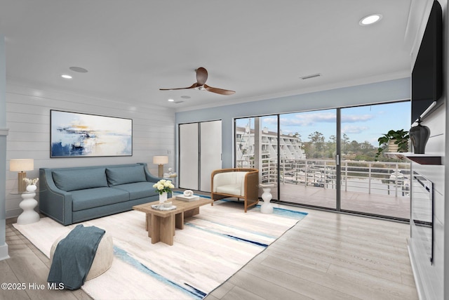 living room featuring visible vents, ceiling fan, ornamental molding, wood finished floors, and recessed lighting