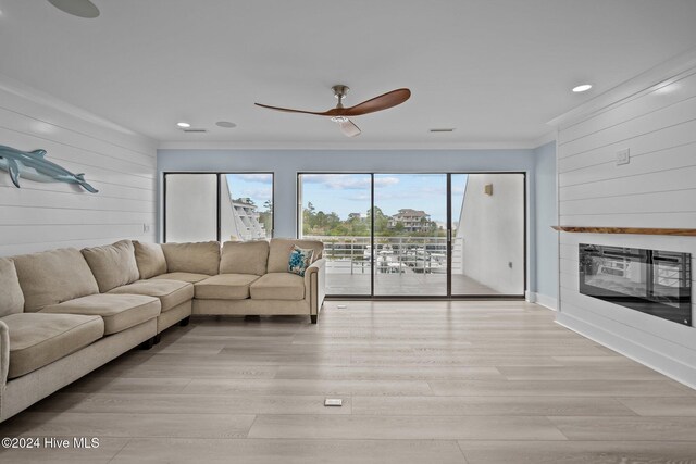 living room featuring crown molding, ceiling fan, and light wood-type flooring