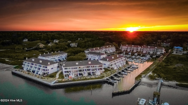 aerial view at dusk featuring a water view