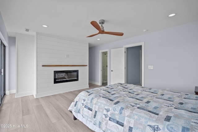 bedroom featuring recessed lighting, visible vents, a fireplace, and light wood-style flooring