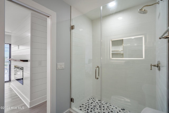 full bathroom featuring a shower stall and wood finished floors