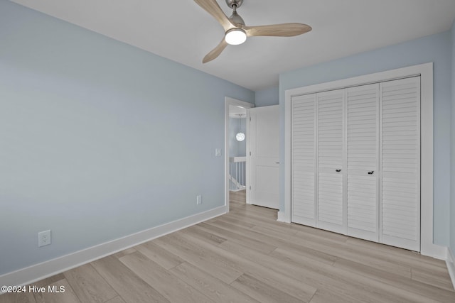 unfurnished bedroom with a ceiling fan, a closet, light wood-style flooring, and baseboards