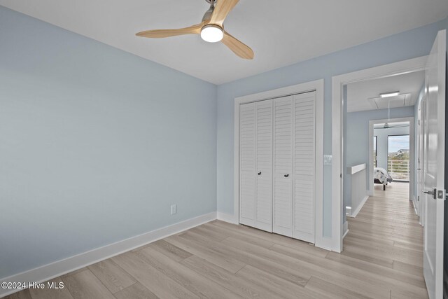 bedroom with ceiling fan, a large fireplace, light hardwood / wood-style floors, and access to outside