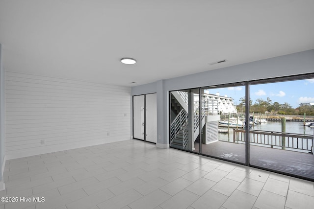 spare room featuring a water view and visible vents