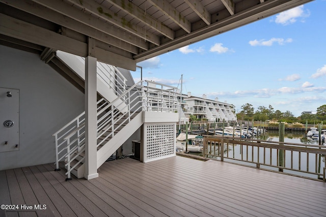 wooden deck with a water view and a dock